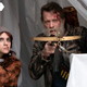 A girl and a man hold crossbows, presumably aimed at vampires.